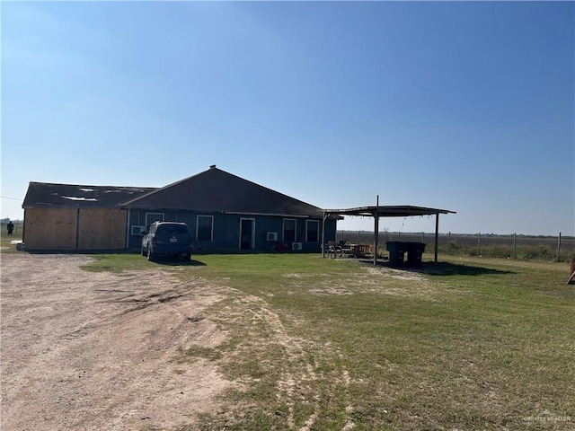 back of house with an outdoor structure and a yard