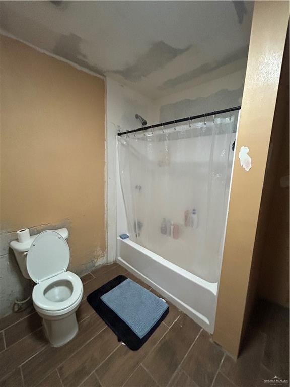 bathroom featuring shower / bath combination with curtain and toilet