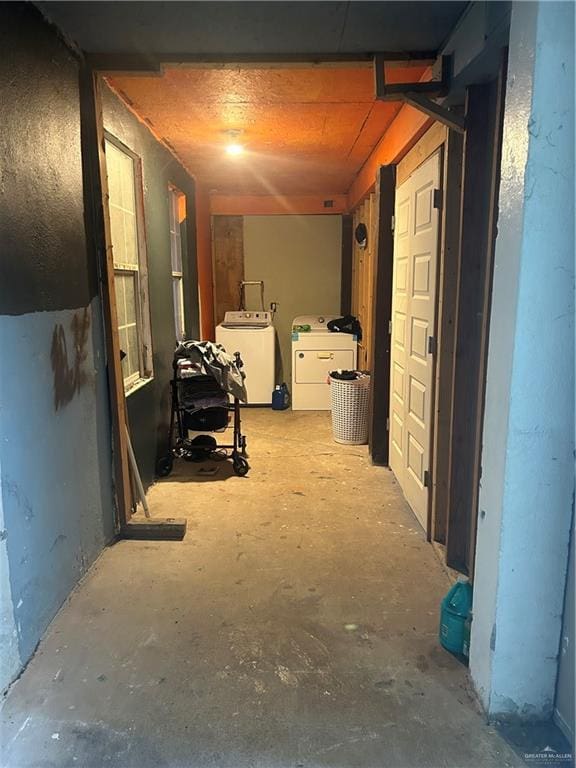 hallway featuring separate washer and dryer and concrete floors