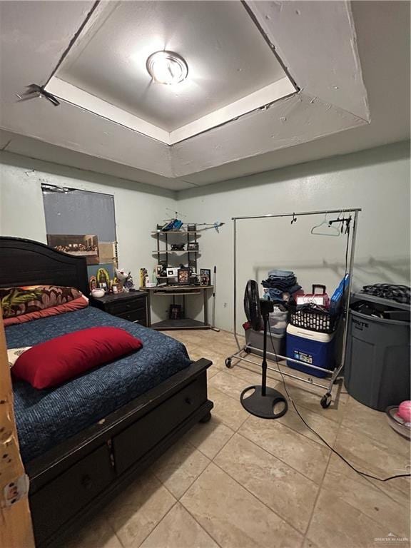 tiled bedroom featuring a raised ceiling