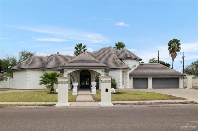 view of front of property with french doors, a front lawn, and a garage