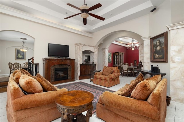 tiled living room featuring a raised ceiling and ceiling fan with notable chandelier