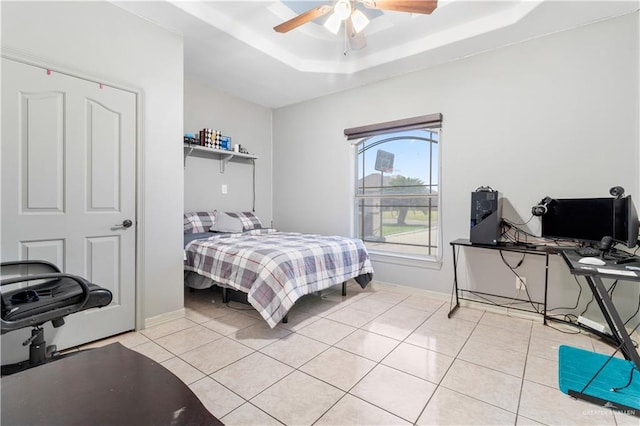 bedroom featuring light tile patterned floors, a raised ceiling, and ceiling fan