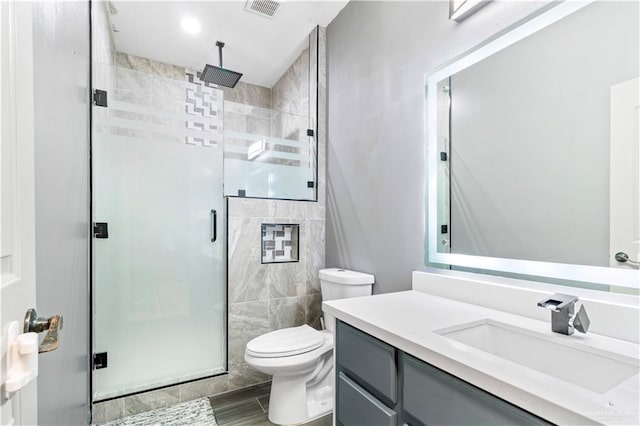 bathroom with vanity, toilet, and an enclosed shower