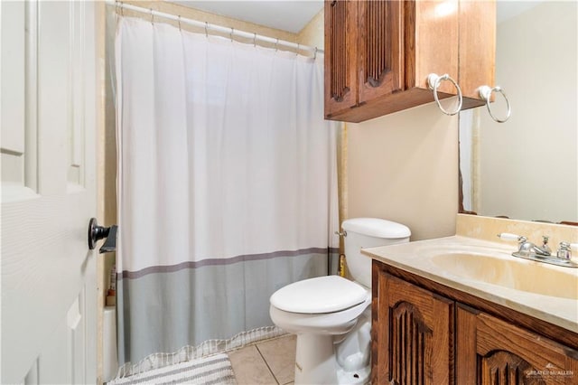 bathroom with toilet, vanity, and tile patterned floors