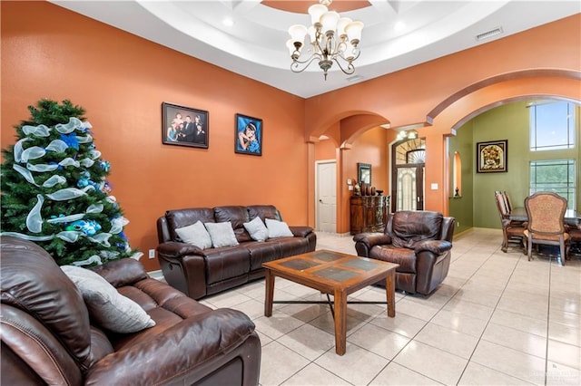 living room featuring light tile patterned floors, an inviting chandelier, and a raised ceiling