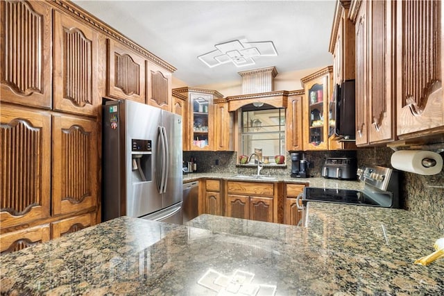 kitchen with stone countertops, stainless steel appliances, tasteful backsplash, and sink