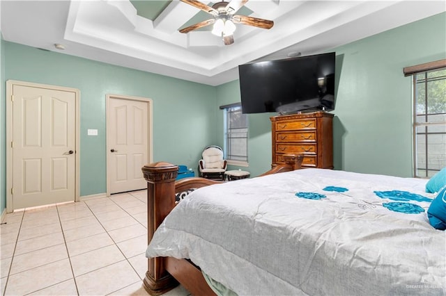 tiled bedroom featuring ceiling fan and a raised ceiling