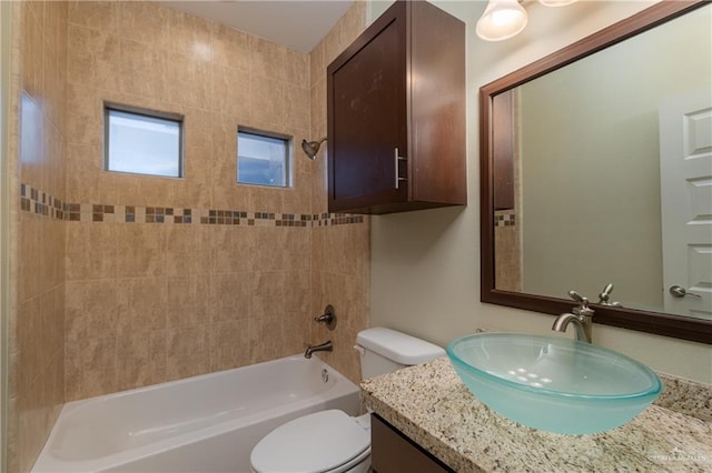 full bathroom with vanity, tiled shower / bath combo, and toilet