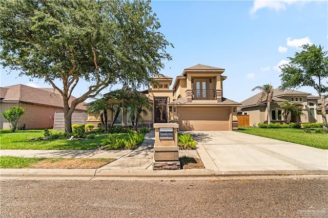 1703 Audrey Dr, Mission, TX 78572 - mediterranean / spanish house featuring a balcony, driveway, french doors, a garage, and stucco siding