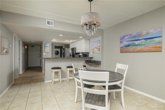 dining area with a chandelier, light tile patterned floors, baseboards, stacked washer / drying machine, and recessed lighting