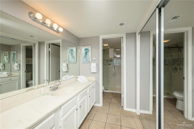 bathroom featuring toilet, tile patterned flooring, vanity, and a shower stall