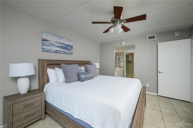 bedroom with ensuite bath, light tile patterned floors, baseboards, and a ceiling fan
