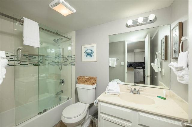 bathroom with toilet, bath / shower combo with glass door, and vanity