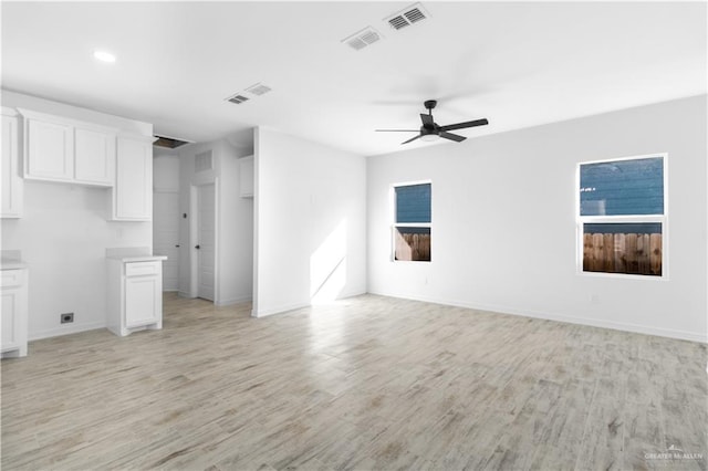 unfurnished living room featuring ceiling fan, light wood-type flooring, and a fireplace