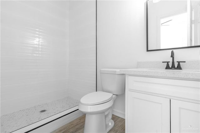 bathroom with toilet, hardwood / wood-style flooring, a shower, and vanity