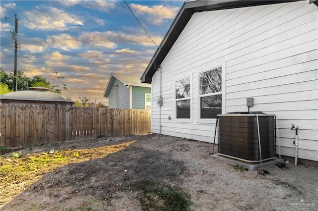 property exterior at dusk featuring central AC unit