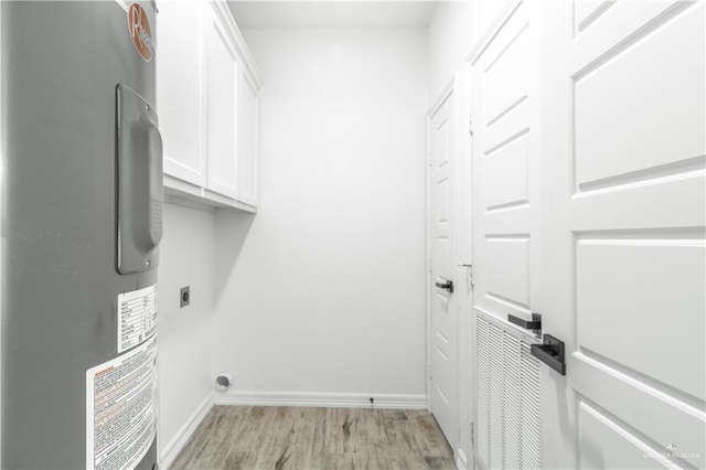 clothes washing area featuring water heater, light wood-type flooring, cabinets, and hookup for an electric dryer