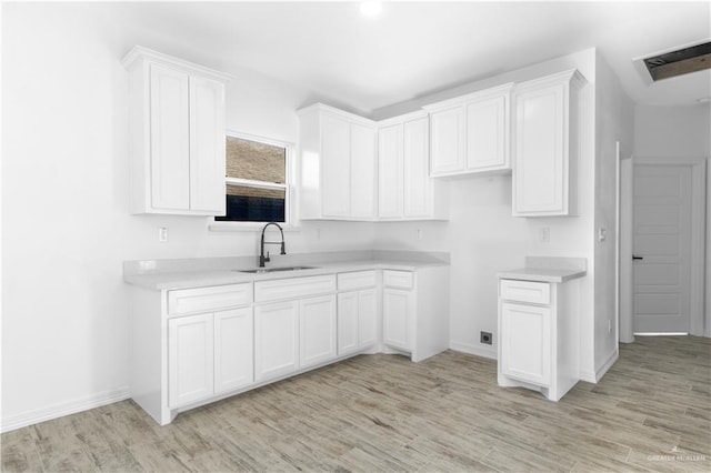 kitchen featuring sink, white cabinetry, and light hardwood / wood-style flooring