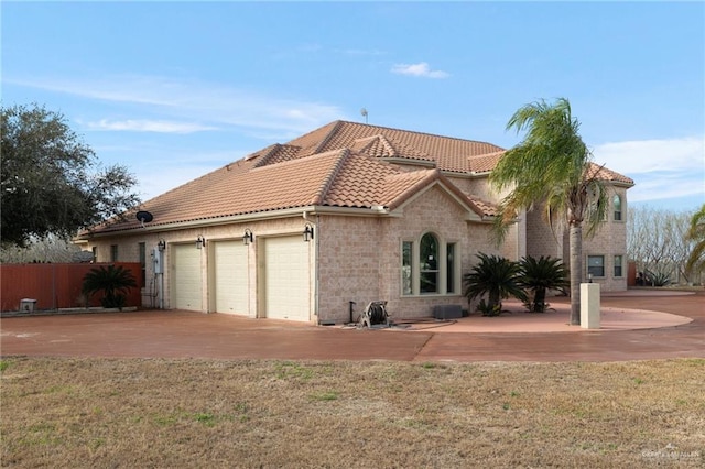 mediterranean / spanish house with a garage and a front lawn