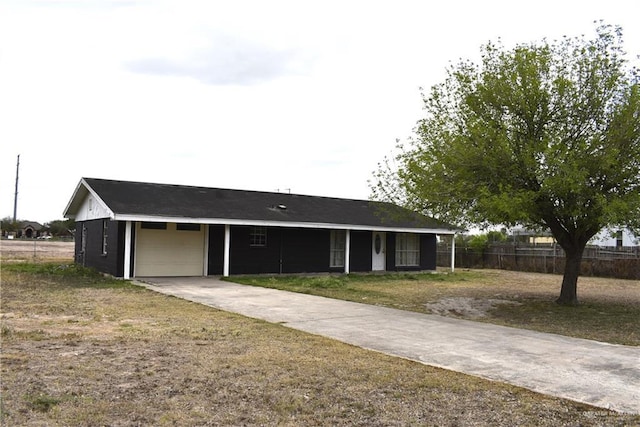 exterior space featuring concrete driveway, an attached garage, and fence