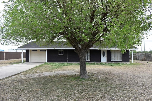 view of front facade with an attached garage, fence, and driveway