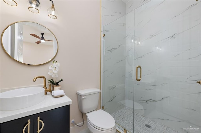 bathroom with vanity, toilet, a shower with door, and ceiling fan