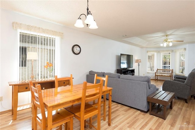 dining room featuring light wood-type flooring and ceiling fan with notable chandelier