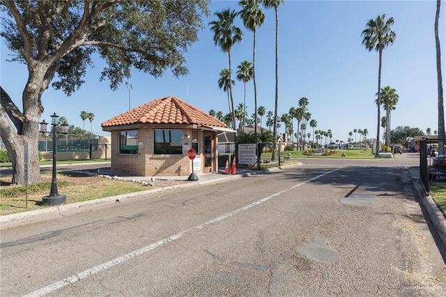 view of road featuring a gated entry and curbs
