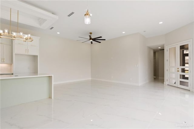 unfurnished room featuring ceiling fan with notable chandelier