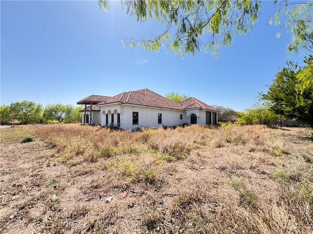 back of house with a tile roof