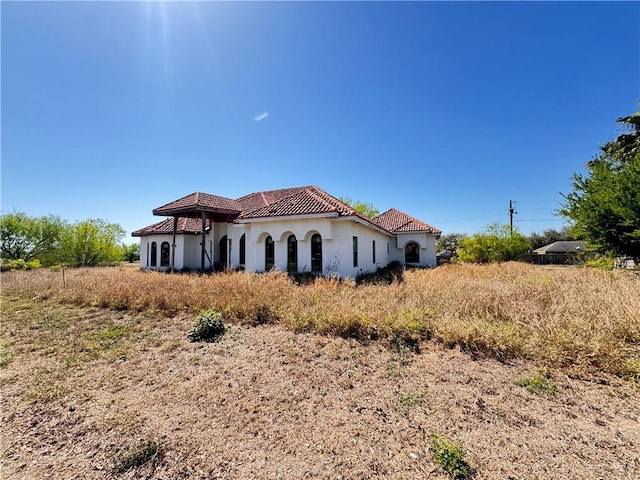 view of front of property featuring stucco siding and a tiled roof