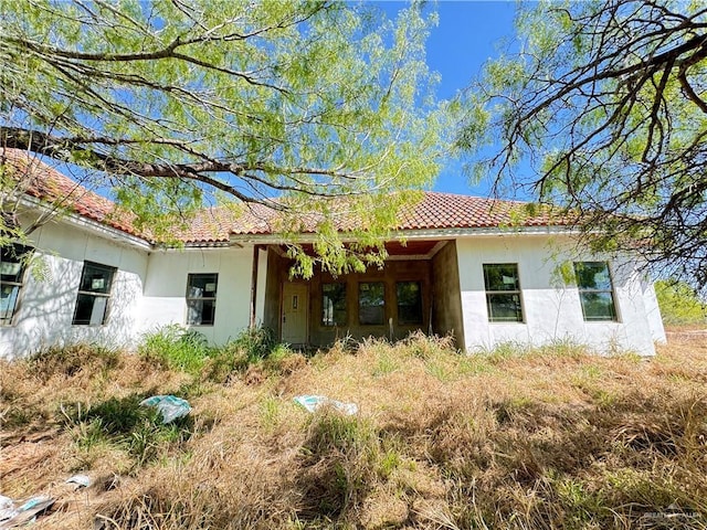 view of front facade featuring a tile roof and stucco siding