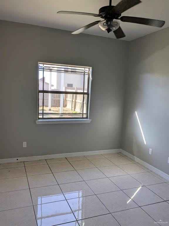 spare room with ceiling fan and light tile patterned flooring