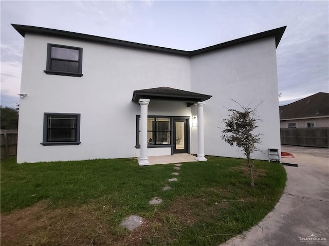 rear view of house featuring a lawn