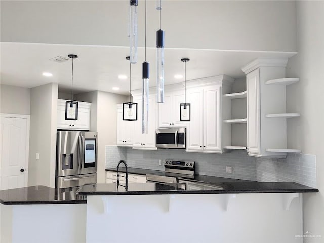 kitchen featuring kitchen peninsula, stainless steel appliances, and hanging light fixtures