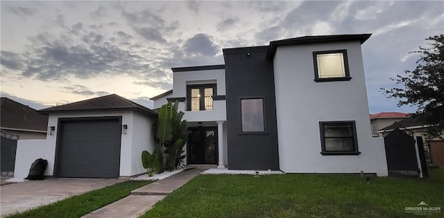 view of front of property featuring a garage and a lawn