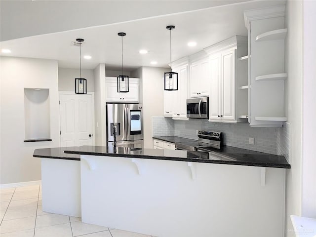 kitchen featuring pendant lighting, a kitchen breakfast bar, white cabinetry, and appliances with stainless steel finishes