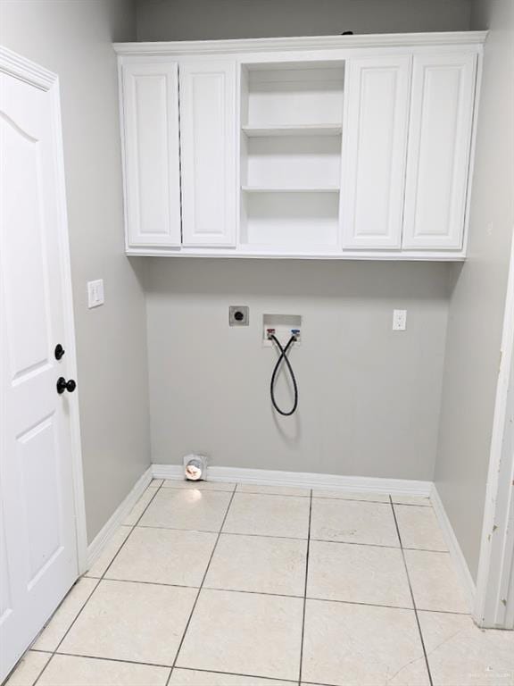 clothes washing area featuring hookup for an electric dryer, washer hookup, cabinets, and light tile patterned flooring