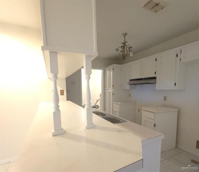 kitchen featuring light tile patterned floors, white cabinetry, and sink