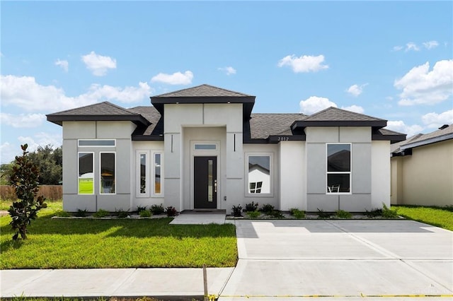 2012 Trinity St, Donna, TX 78537 - prairie-style home featuring roof with shingles, fence, stucco siding, and a front lawn