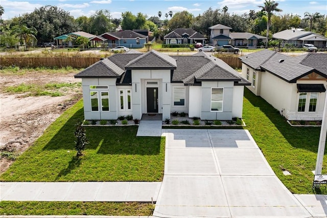 2012 Trinity St, Donna, TX 78537 - view of front facade featuring stucco siding, driveway, a residential view, and a front yard