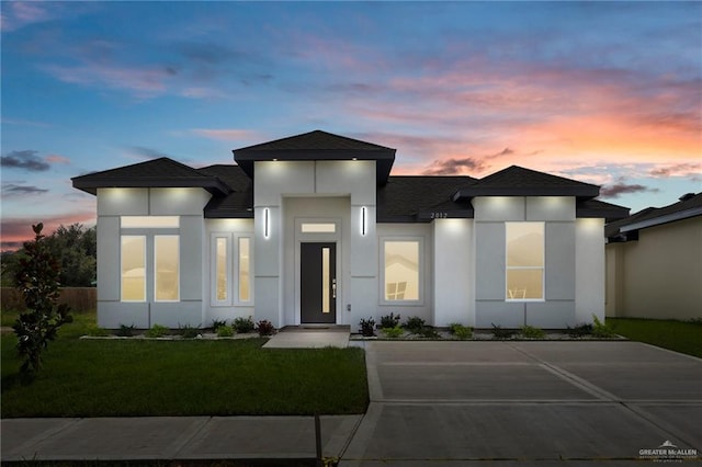 2012 Trinity St, Donna, TX 78537 - view of front of house featuring a yard, a shingled roof, and stucco siding