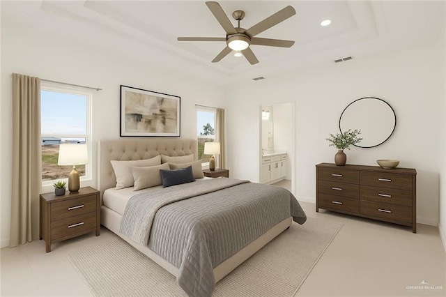 2012 Trinity St, Donna, TX 78537 - bedroom with a tray ceiling, ensuite bathroom, visible vents, and multiple windows