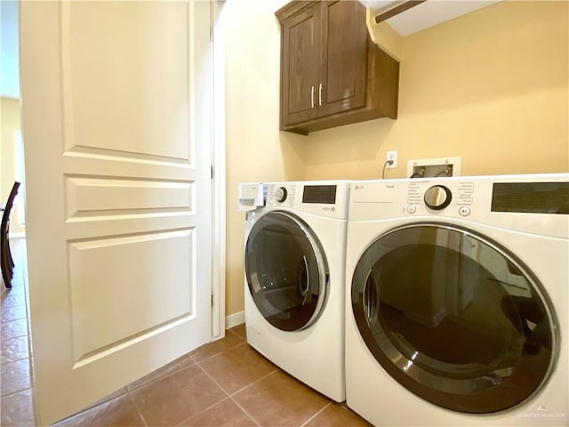 laundry room with cabinets, washing machine and dryer, and tile patterned flooring