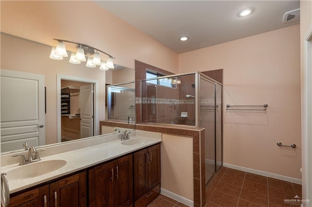 bathroom featuring tile patterned flooring, vanity, and a shower with shower door