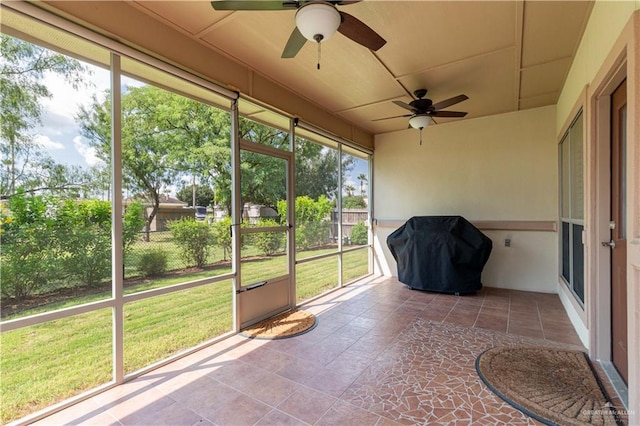 unfurnished sunroom with ceiling fan