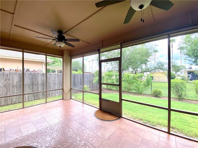 unfurnished sunroom with ceiling fan