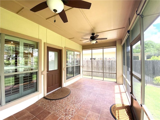 unfurnished sunroom featuring ceiling fan