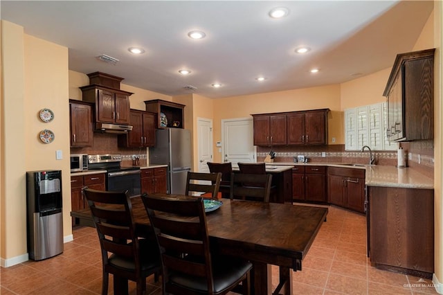 kitchen with ventilation hood, stainless steel appliances, tasteful backsplash, and sink